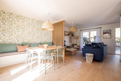 un salon avec une table et un canapé bleu dans l'établissement Villas Indigo 40 personnes, à La Teste-de-Buch