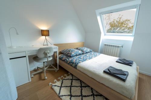 une chambre avec un lit, un bureau et une fenêtre dans l'établissement Maison de ville avec terrasse Proche métro, à Rennes