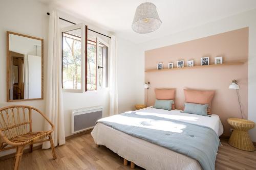 une chambre avec un lit, une chaise et un miroir dans l'établissement Villas Indigo 40 personnes, à La Teste-de-Buch