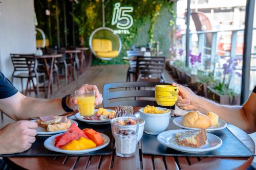 two people sitting at a table with plates of food at i5 Hotel Águas Claras in Brasilia