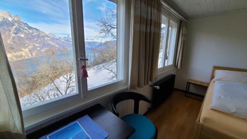 a room with a window and a desk with a laptop at Hotel Cafe Seeblick in Filzbach