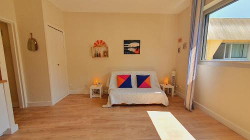 a room with a bed and two tables and a window at Suite Incas pour 2 CLIM WIFI Piscine Centre-ville - ROSSIconciergerie - Linge inclus in La Grande-Motte