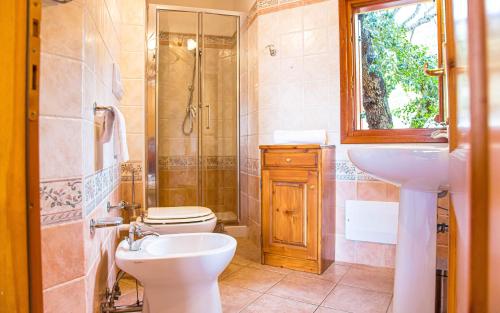 a bathroom with a sink and a toilet and a shower at Villetta con giardino, IUN Q3445 in Cala Gonone