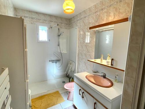 une salle de bain avec un lavabo, des toilettes et une douche dans l'établissement Maison familiale toute équipée St Gilles X vie 85, à Saint-Gilles-Croix-de-Vie