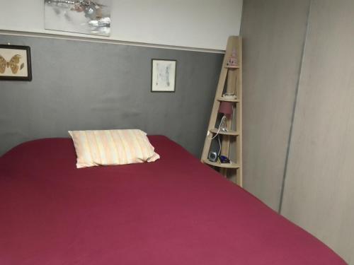 a bedroom with a bed with a red blanket at la maison bonheur in Feytiat
