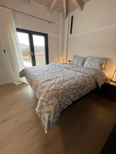 a large bed in a bedroom with a large window at Arachova Villa Paris in Kalívia