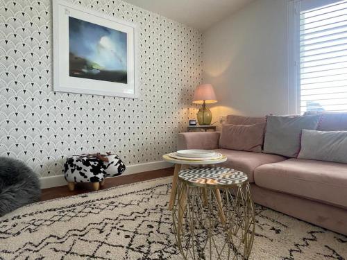 a living room with a couch and a table at Baywatch Mawgan Porth Spacious Home sleeps 9, Games room, Parking & Garden in Mawgan Porth