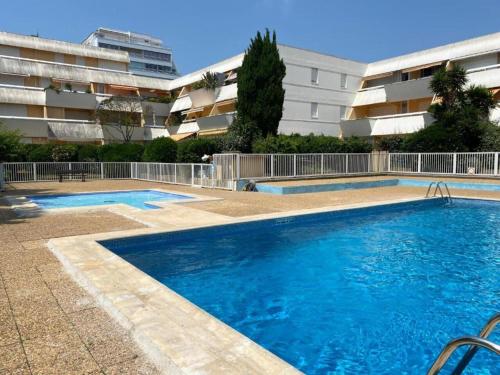 une grande piscine devant un immeuble dans l'établissement Suite Incas pour 2 CLIM WIFI Piscine Centre-ville - ROSSIconciergerie - Linge inclus, à La Grande Motte