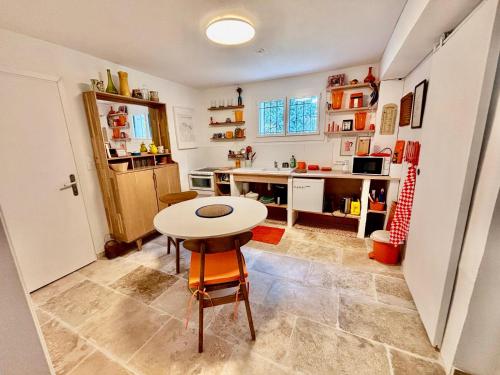 a kitchen with a table and a small table and chairs at Beau studio dans mas provençal in Avignon