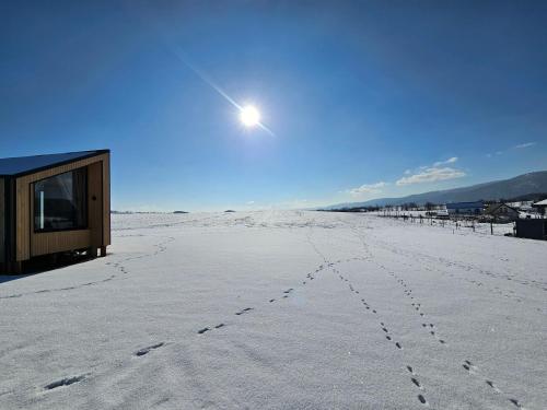 a house on the beach with footprints in the snow at AleWidok - domek na wynajem z widokiem na Góry Sowie in Ostroszowice