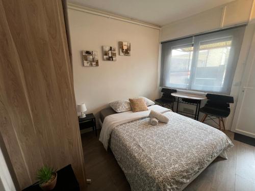 a bedroom with a bed and a table and a window at Studio k Maisons des Examens, ligne 14, Paris in Gentilly