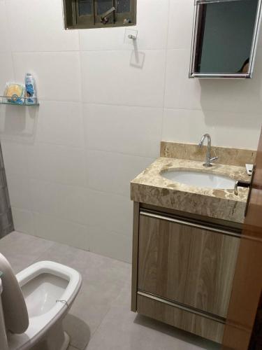 a bathroom with a sink and a tub and a toilet at Casadapraça in Goianésia