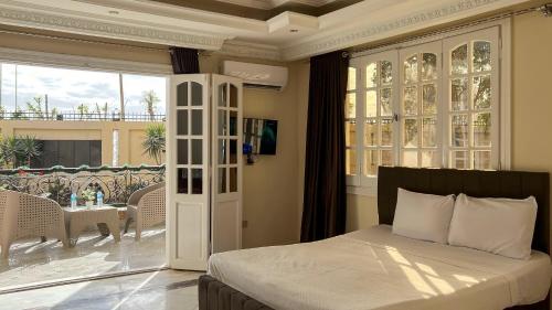 a bedroom with a bed and a balcony at Turquoise Pyramids palace in Giza
