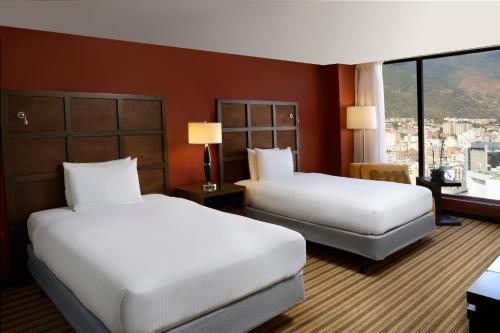 a hotel room with two beds and a window at Renaissance Caracas La Castellana Hotel in Caracas