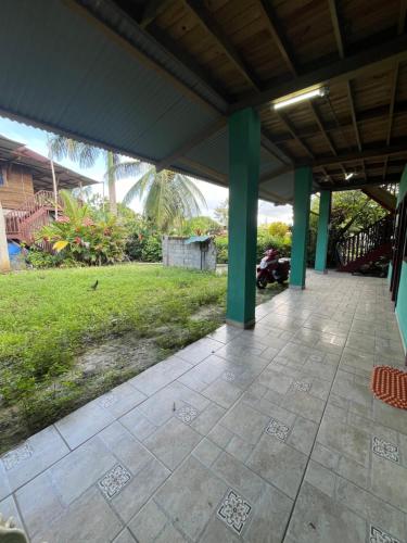 a patio with green columns and a yard at Valerie Emanuel Apartments in Bocas del Toro