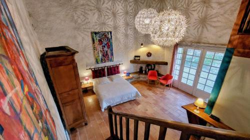 een slaapkamer met een bed en een kroonluchter bij Maison Catalina in Gignac