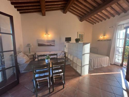 salon ze stołem i łóżkiem w obiekcie Casa "Ale" con piscina comune e bellissimo giardino a 5 minuti dal mare w mieście Cecina
