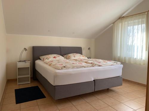 ein Schlafzimmer mit einem Bett in einem Zimmer mit einem Fenster in der Unterkunft Amselstern Binz in Binz