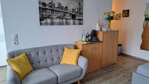 a living room with a gray couch and yellow pillows at Haus Allgäu Ruh in Görisried