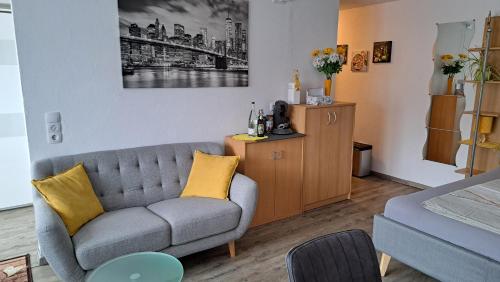 a living room with a gray couch and yellow pillows at Haus Allgäu Ruh in Görisried