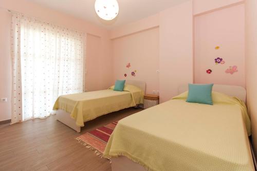 a bedroom with two beds and a window at Villa Eco Blu in Marathopolis