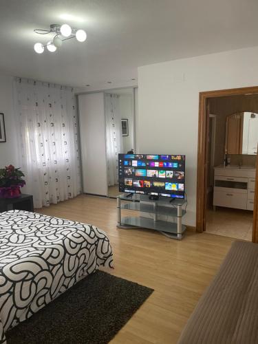 a bedroom with a bed and a flat screen tv at Maravillosa villa con piscina y barbacoa in Puigventos