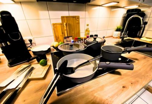 a kitchen with three pots and pans on a stove at Ferienapartment Saarbrücken Zentrumsnah mit Luxus-Heimkino, Grill, Balkon & Miele Küche in Saarbrücken