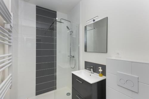une salle de bain blanche avec un lavabo et une douche dans l'établissement T2 L'Indomptable, à Brest