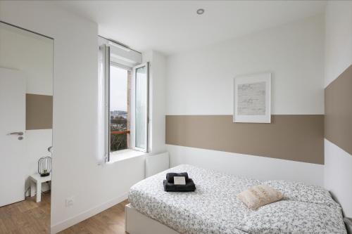 une chambre blanche avec un lit et une fenêtre dans l'établissement T2 L'Indomptable, à Brest