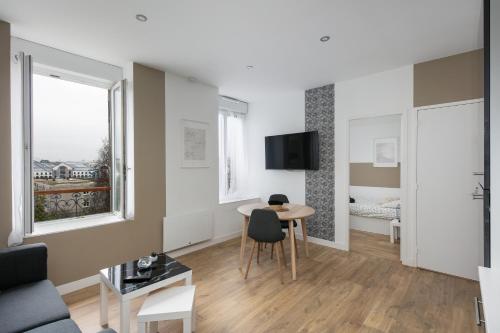 un salon avec une table et un canapé dans l'établissement T2 L'Indomptable, à Brest