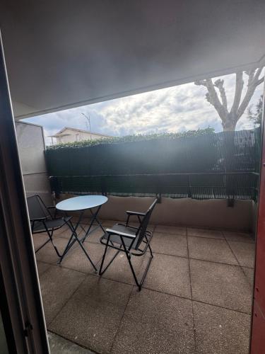 y balcón con vistas a una mesa y sillas. en Appartement, Cozy trois, en Toulouse