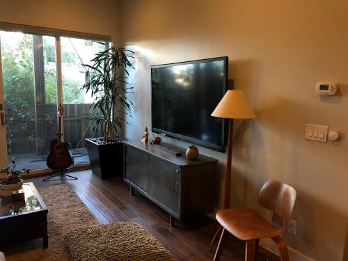 a living room with a large flat screen tv at Beautiful Cottage, hot tub, in great neighborhood in San Francisco