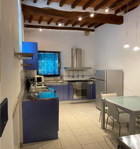a large kitchen with blue cabinets and a table at A un passo dal Palio in Siena