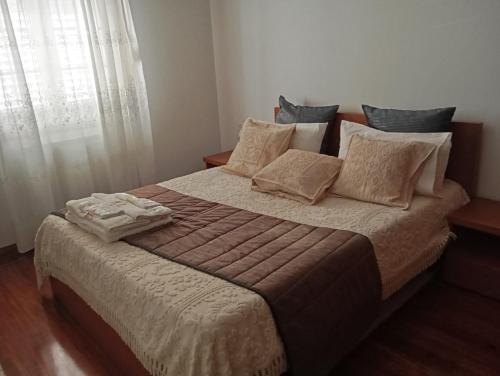 a bedroom with a large bed with pillows at Casa do Outeirinho in Campos