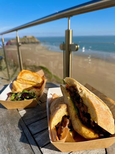 a sandwich and chips on a table near the beach at Clarence House Hotel in Tenby