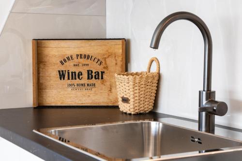 a kitchen counter with a sink and a wine bar sign at Black Diamond in Novalja