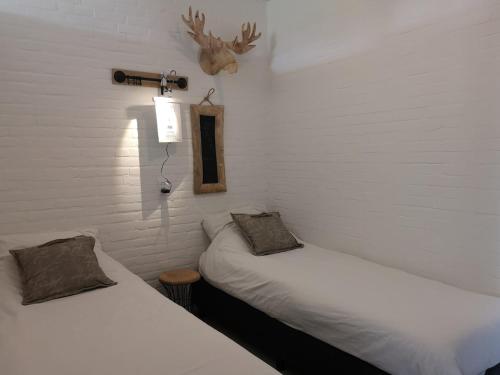 two beds in a room with white walls at Vakantiewoning Bruinisse aan Jachthaven Zeeland, VP012 in Bruinisse