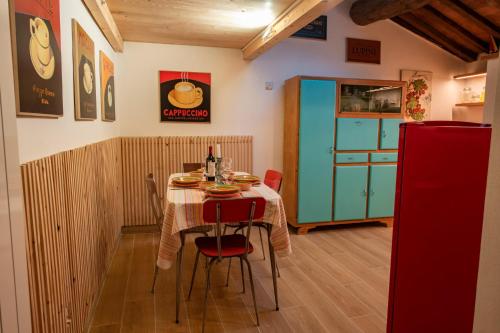 a dining room with a table and a green cabinet at Le finestre sulle stelle in Gerfalco