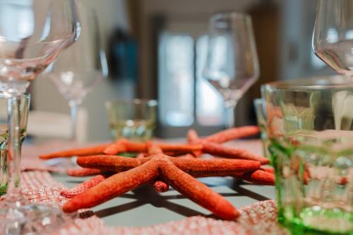 a group of carrots on a table with wine glasses at Casa Mauro e Roberta Zingaro in Castellammare del Golfo