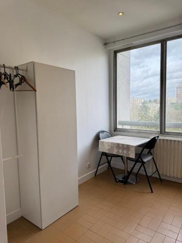 une pièce vide avec une table et une fenêtre dans l'établissement Cozy Urban - Close to Paris CDG, à Sarcelles