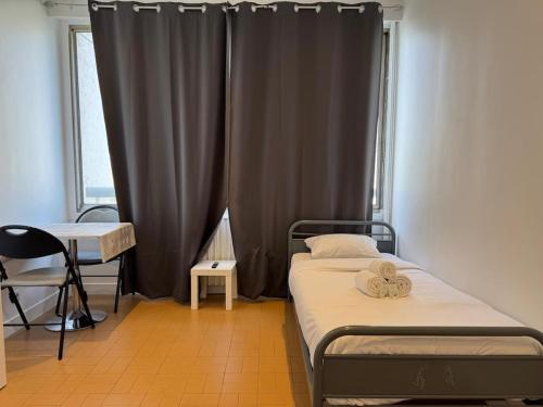 une petite chambre avec deux lits et une fenêtre dans l'établissement Cozy Urban - Close to Paris CDG, à Sarcelles