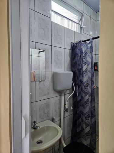 a small bathroom with a sink and a shower at Terraço sol e lua in Belém