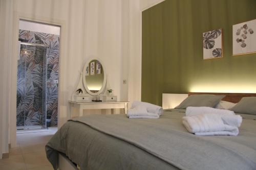 a bedroom with a large bed and a mirror at Nina Suites in Salerno
