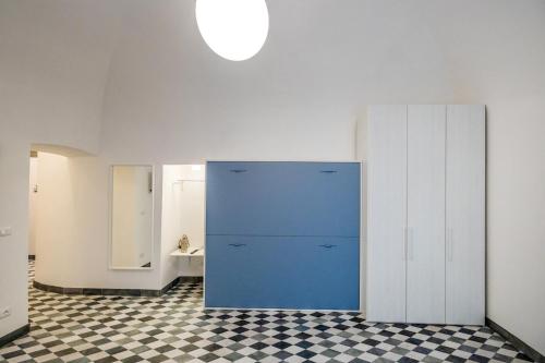 a blue cabinet in a room with a checkered floor at Il Pesciolino Blu Apartment in Finale Ligure
