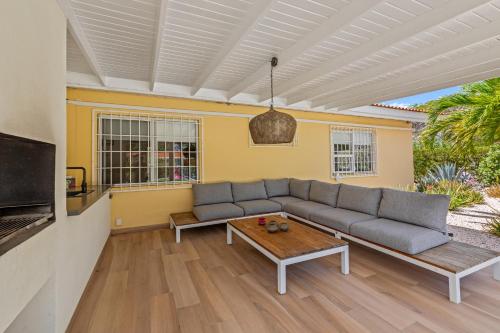 a living room with a couch and a table at Kas di Rosa Curacao luxurious holiday home in Grote Berg