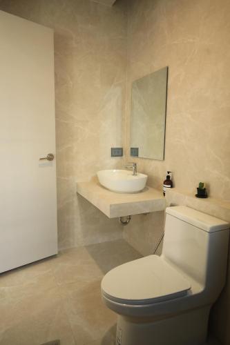 a bathroom with a white toilet and a sink at BAAN BIBI near Saturday walking street in Chiang Mai