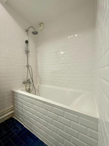 une baignoire blanche avec douche dans une salle de bain dans l'établissement Studio Tour Eiffel La Muette, à Paris