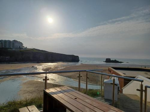 Blick auf einen Strand mit aufgehender Sonne über dem Meer in der Unterkunft Cosy Perranporth caravan, Cornwall in Perranzabuloe
