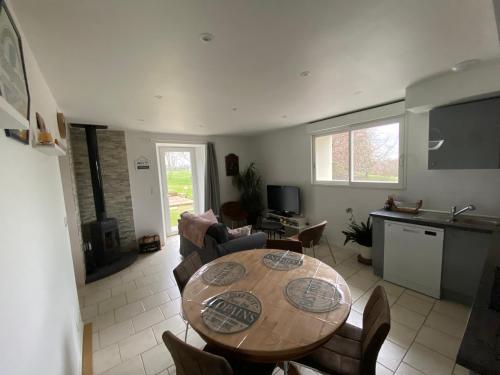 un salon avec une table et des chaises en bois dans l'établissement Domaine De Domingeal Meublé de Tourisme 3 étoiles, à Saint-Germain-les-Vergnes
