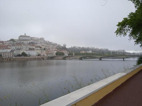 a bridge over a river with a city in the background at Casa da Zendinha in Coimbra